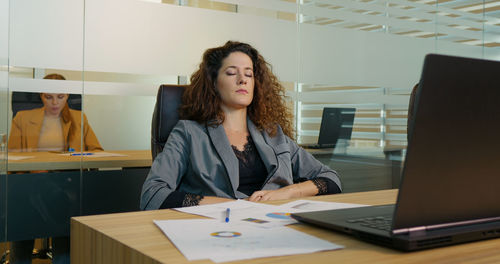 Tired business woman lying on her back in office. 