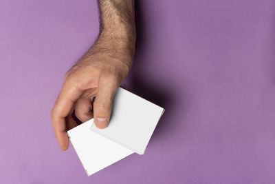 Cropped hand of woman holding paper