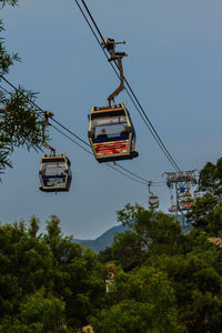 Low angle view of overhead cable cars against clear sky