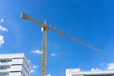 Low angle view of crane against blue sky