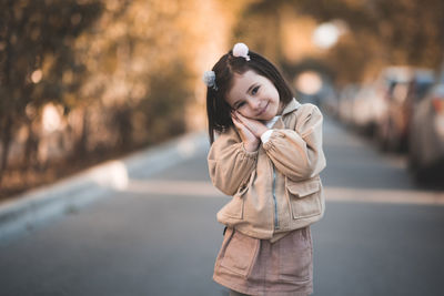 Portrait of girl in jacket standing on road