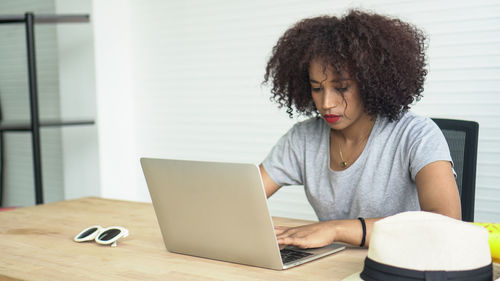 Woman using mobile phone while sitting on table