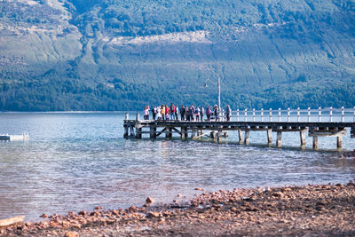 View of tourists on pier in sea during winter