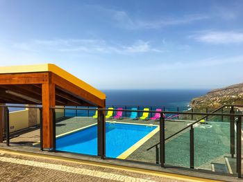 View of swimming pool by sea against sky