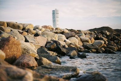 Rocks by sea against sky