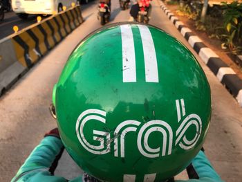 High angle view of person wearing green helmet with grab text