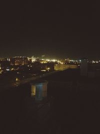 Illuminated cityscape against sky at night