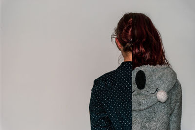 Rear view of woman standing against white background