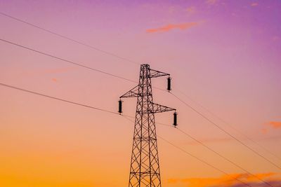 Low angle view of silhouette electricity pylon against sky during sunset