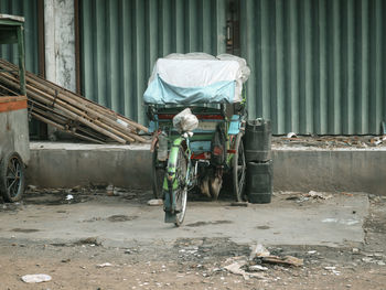 An old rickshaw parked in front of a closed shop