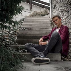 Portrait of man sitting on staircase