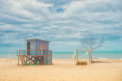 Lifeguard hut on beach against sky