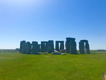 Castle on field against clear blue sky