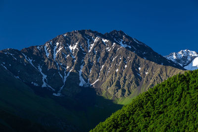 Mountain peaks of chechnya in the caucasus. close-up of red poppy flowers on field