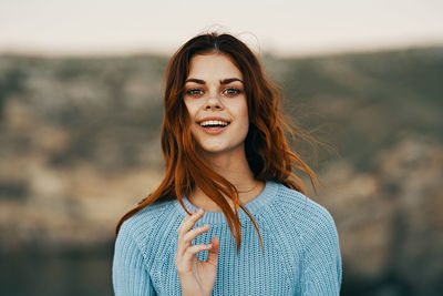 Portrait of smiling young woman standing outdoors