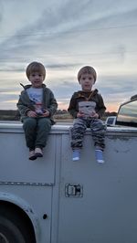 The boys ditting on the truck.