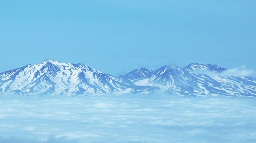 Scenic view of snowcapped mountains against blue sky