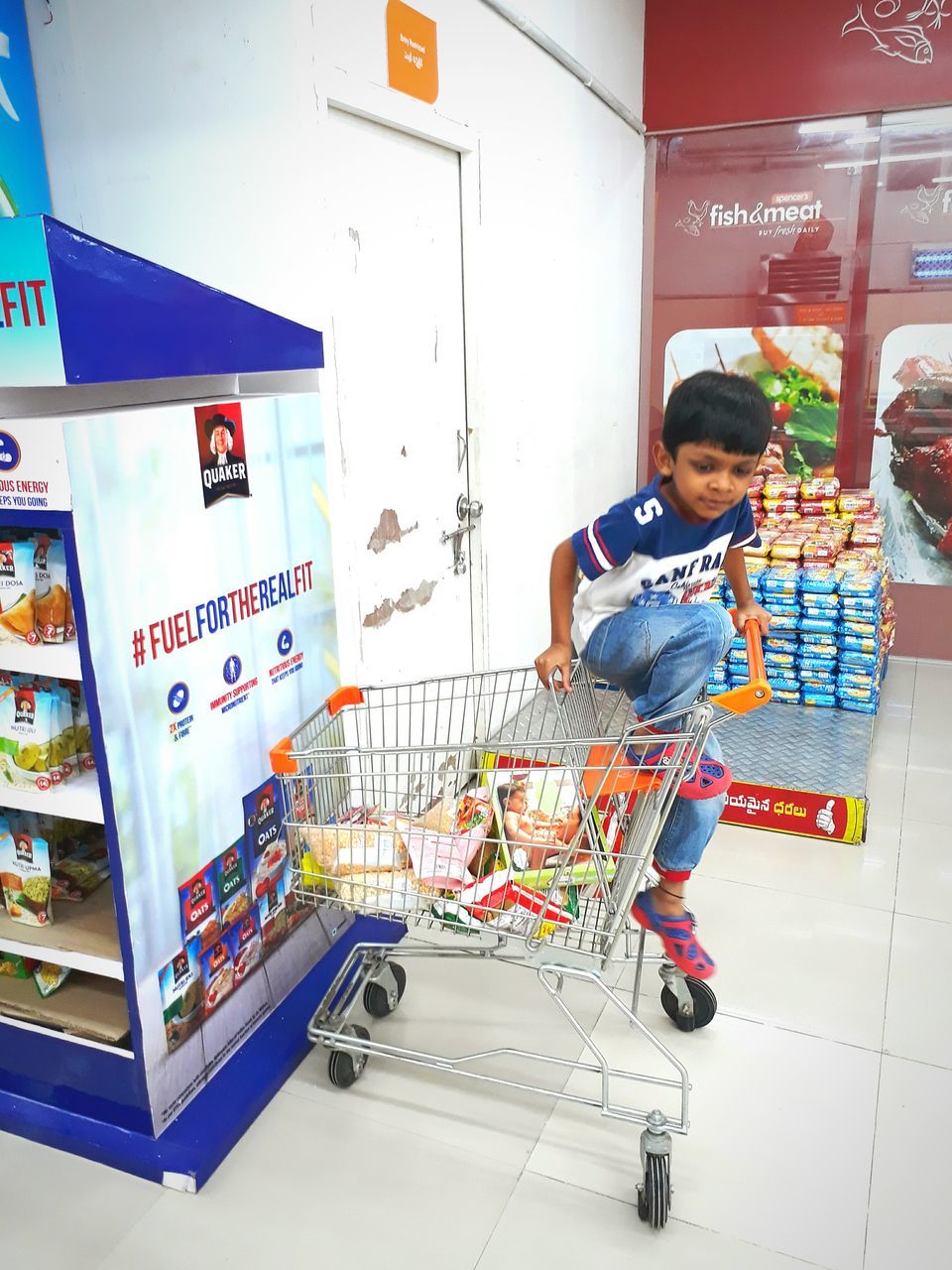 retail, store, supermarket, consumerism, full length, shopping cart, one person, customer, food and drink, real people, buying, groceries, food, standing, smiling, lifestyles, indoors, day, freshness, young adult, people