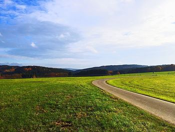 Scenic view of grassy field against sky