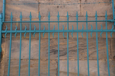 Full frame shot of metal fence against wall