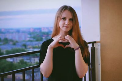 Young woman shaping heart with hands