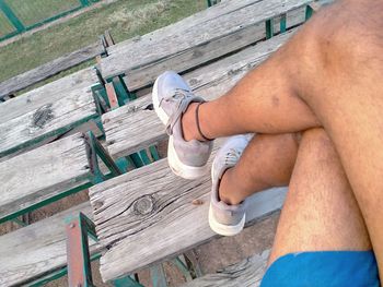 Low section of man relaxing on wood