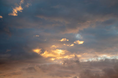 Low angle view of sunlight streaming through clouds