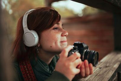 Portrait of young woman photographing camera