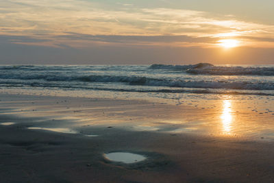 Scenic view of beach against sky during sunset