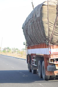 Vehicles on road against clear sky in city