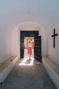 Woman standing by window of building