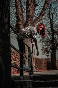 Portrait of woman standing by tree