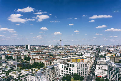 Aerial view of fernsehturm and cityscape against sky during sunny day