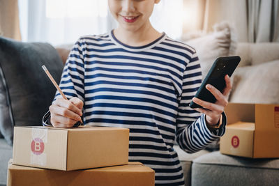 Midsection of woman using mobile phone