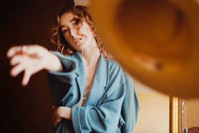 Young woman looking away while sitting on floor