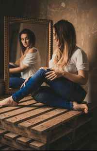 Young woman looking in the mirror