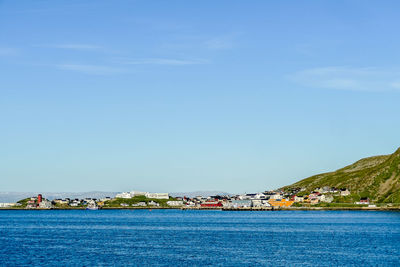 Scenic view of sea by buildings against sky