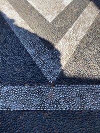 High angle view of street decorated floor with pebbles sunlight and shadow with copy space 