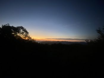 Silhouette trees against sky during sunset