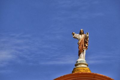 Low angle view of statue against blue sky