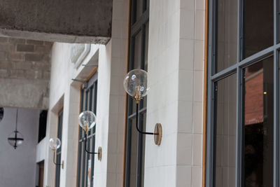 Low angle view of light bulbs hanging on building