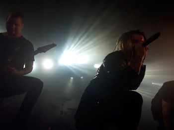 People playing guitar at music concert