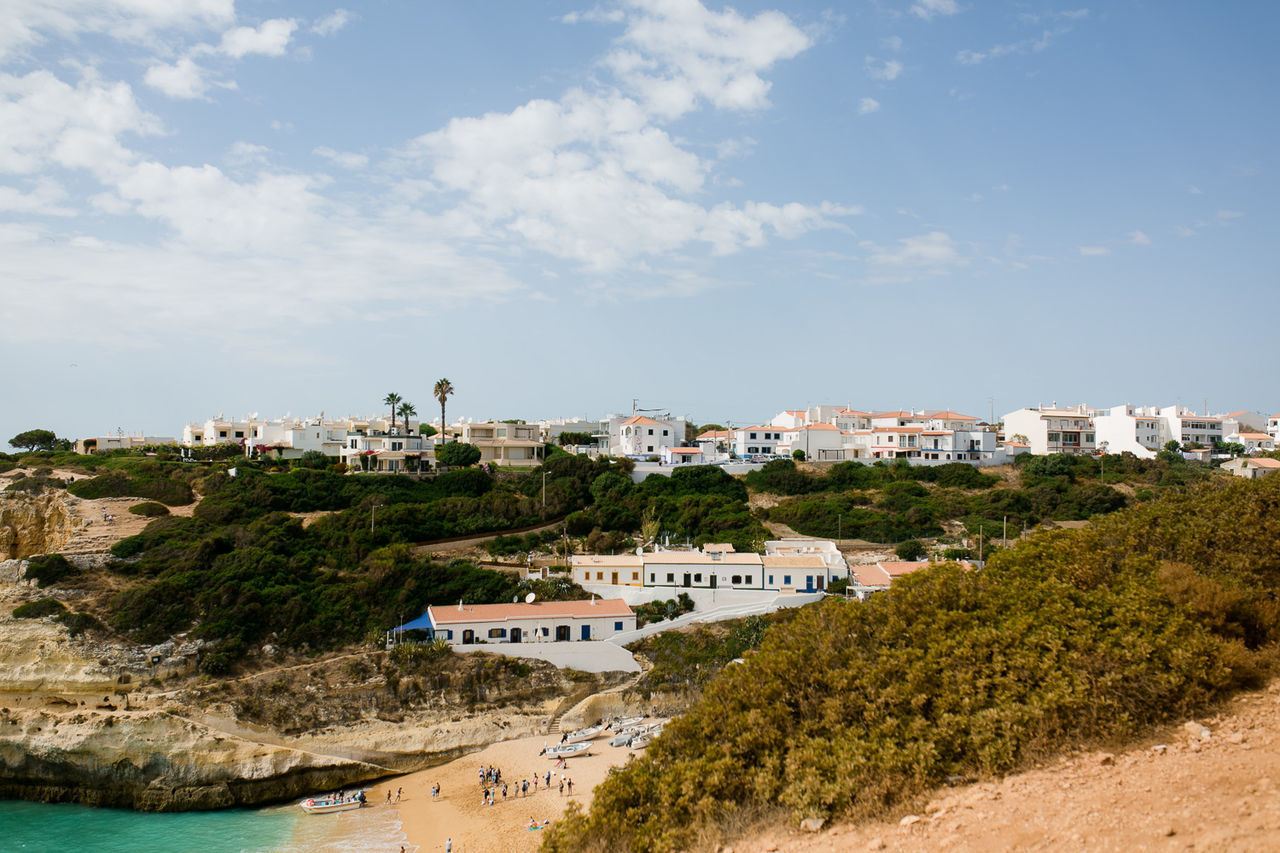 HIGH ANGLE VIEW OF TOWNSCAPE AND SEA AGAINST SKY