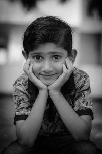 Portrait of boy sitting on sidewalk