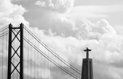 25 de abril bridge by cristo rei against cloudy sky