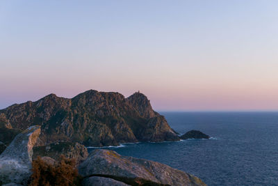 Scenic view of rocks in sea against clear sky