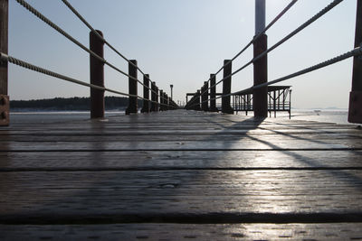 Footbridge over sea against clear sky