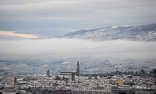 Aerial view of townscape against cloudy sky