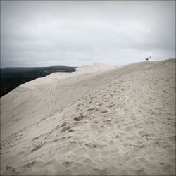 Sand dunes in desert against sky