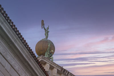 Low angle view of statue of building against cloudy sky